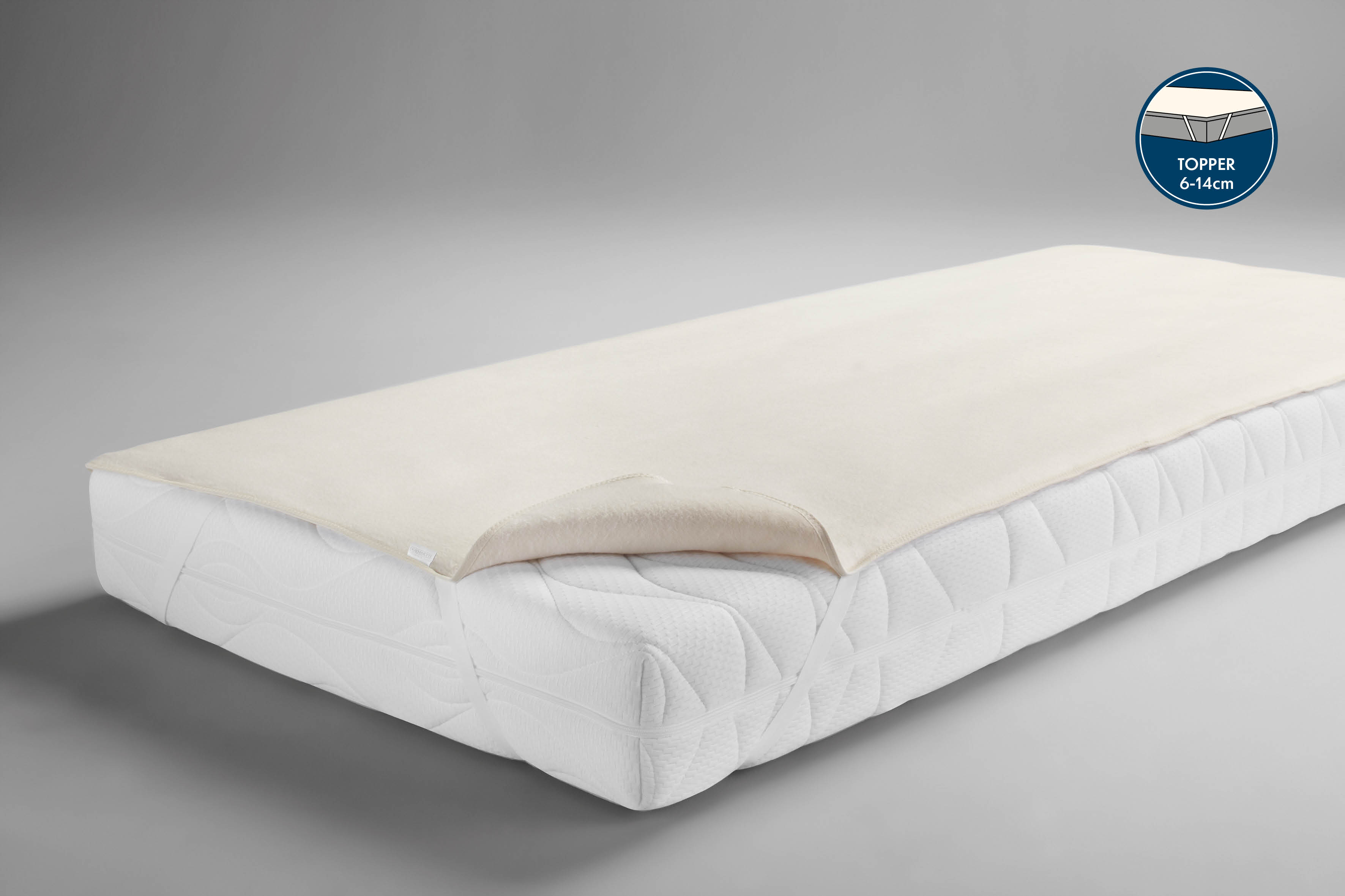 Eine Boxspring Molton Matratzenauflage in der Farbe natur liegt aufgezogen auf der Matratze