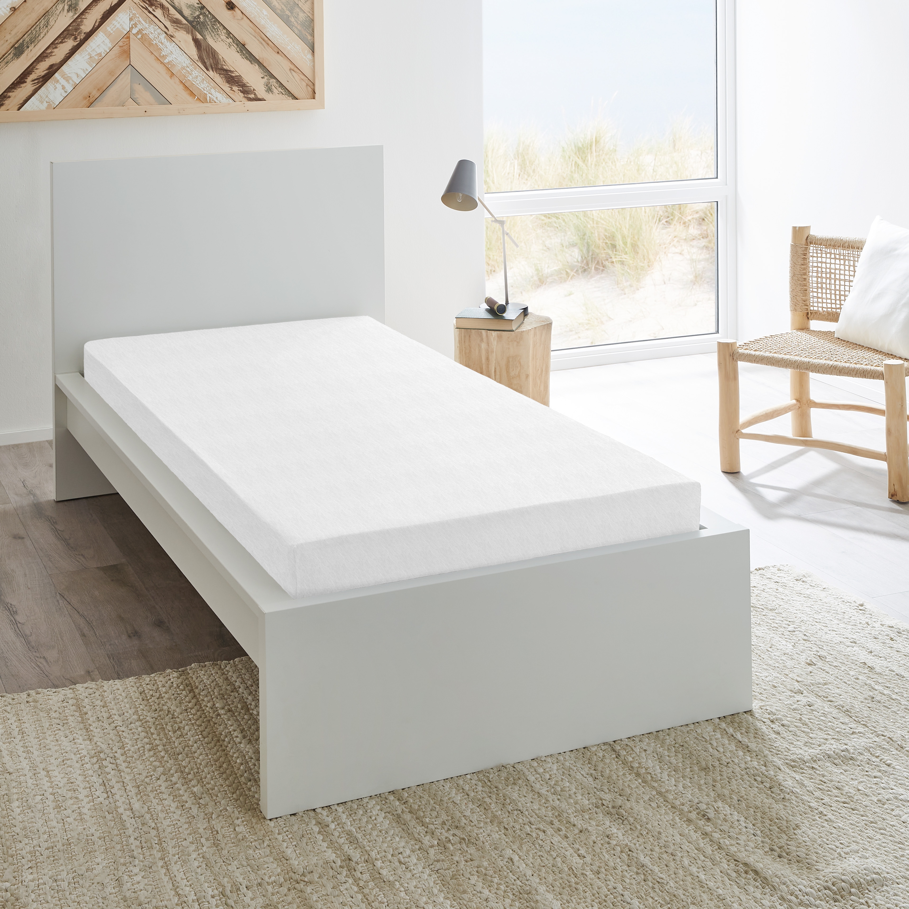 Weißes Spannbetttuch auf einem Bett bezogen