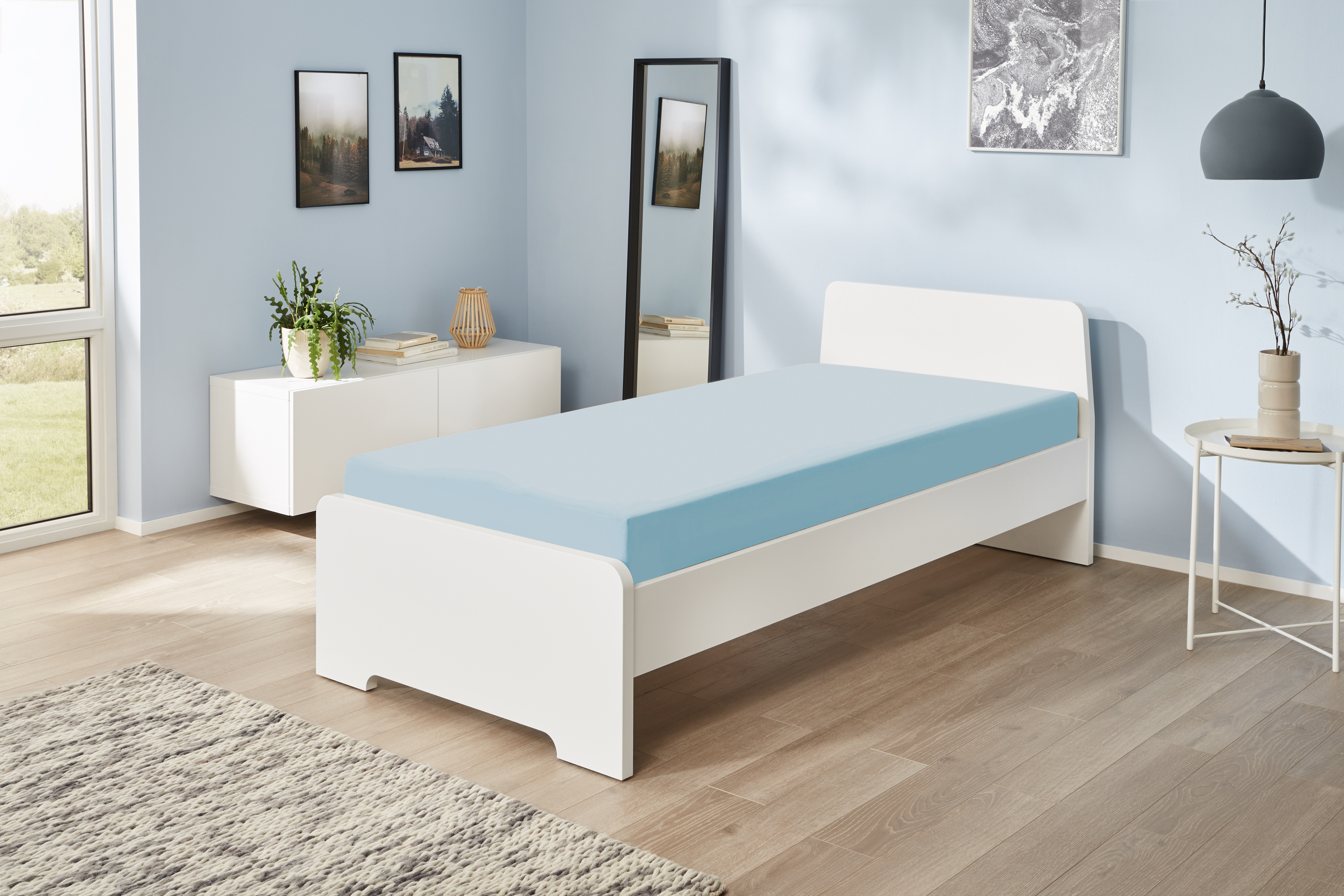 Jerey-Elasthan-Spannbetttuch in der Farbe Hellblau auf einem Bett bezogen