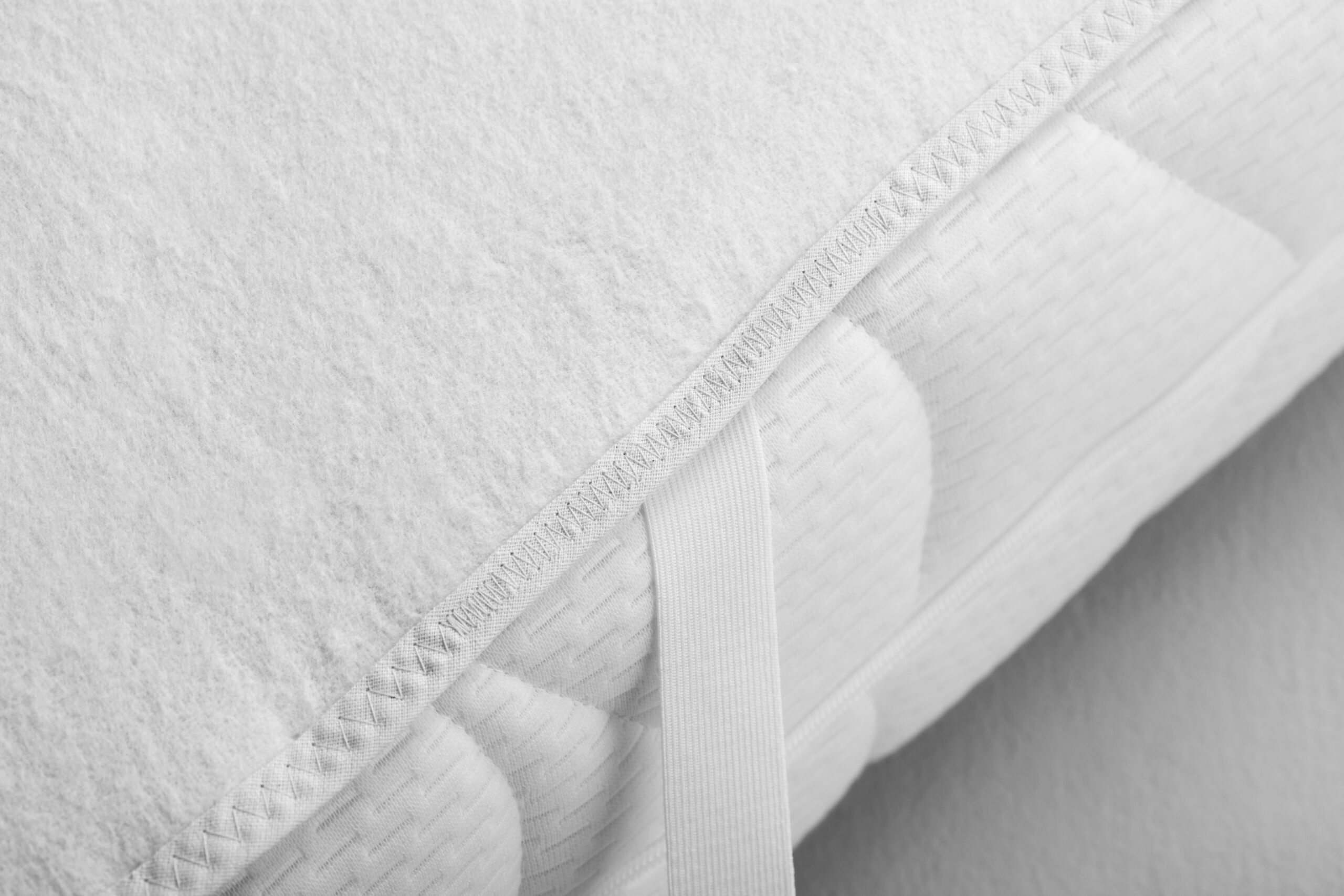 Detailaufnahme zeigt Eckgummi der Premium Matratzenauflage